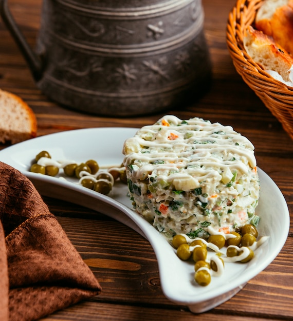 Kostenloses Foto russischer hauptsalat mit erbsen auf dem tisch