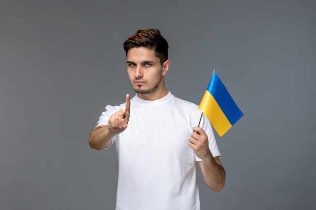 Russischer Konflikt in der Ukraine, hübscher, mutiger Typ im weißen Hemd, der den Finger hält, um den Krieg zu stoppen