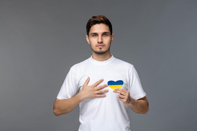 Russischer konflikt in der ukraine hübscher süßer gutaussehender mann im weißen hemd mit haltender brust mit ukraine