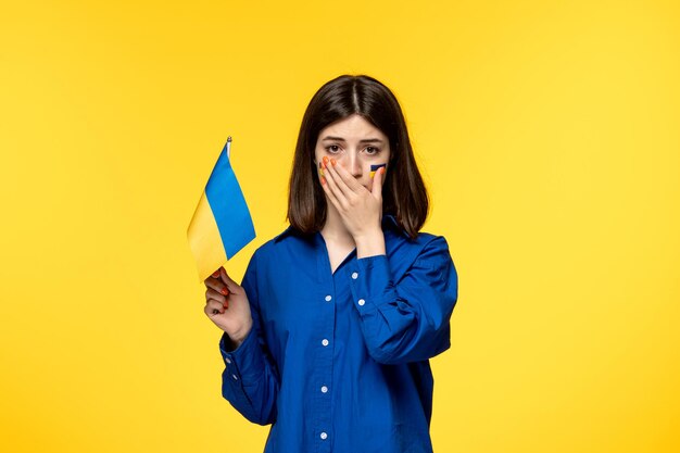Russischer Konflikt in der Ukraine hübsches süßes Mädchen mit Fahnen auf den Wangen, das mit ukrainischer Flagge weint
