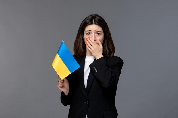 Russischer Konflikt in der Ukraine süße junge Frau mit dunklen Haaren im schwarzen Blazer, die den Mund verärgert weint