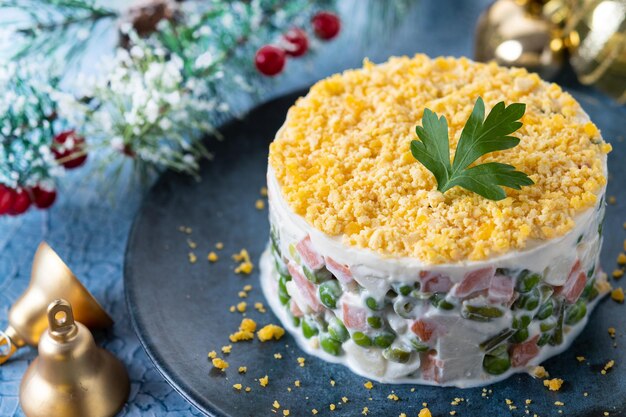 Russischer Salat oder Olivier-Salat zum Weihnachtsessen auf blauer Oberfläche