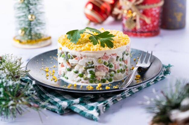 Russischer Salat oder Olivier-Salat zum Weihnachtsessen auf Marmorhintergrund