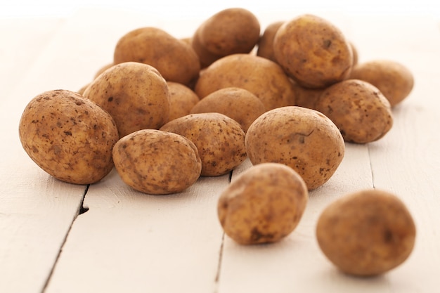 Kostenloses Foto rustikale ungeschälte kartoffeln auf einer tabelle