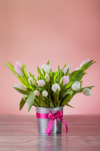 Rustikaler Topf mit weißen frischen Tulpen