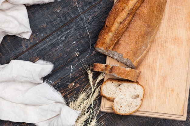 Rustikales Brot auf Holztisch. Dunkler holziger Hintergrund mit freiem Textraum.