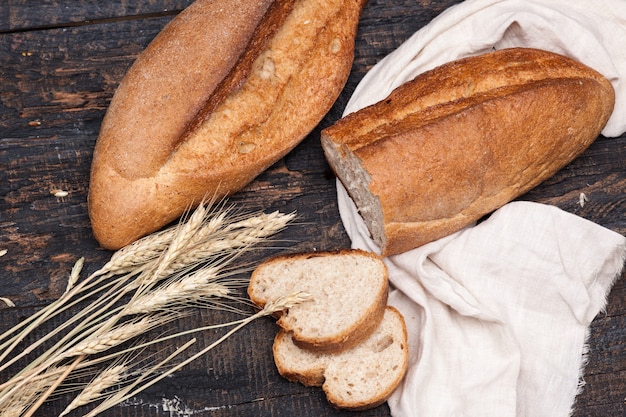 Kostenloses Foto rustikales brot auf holztisch. dunkler holzraum