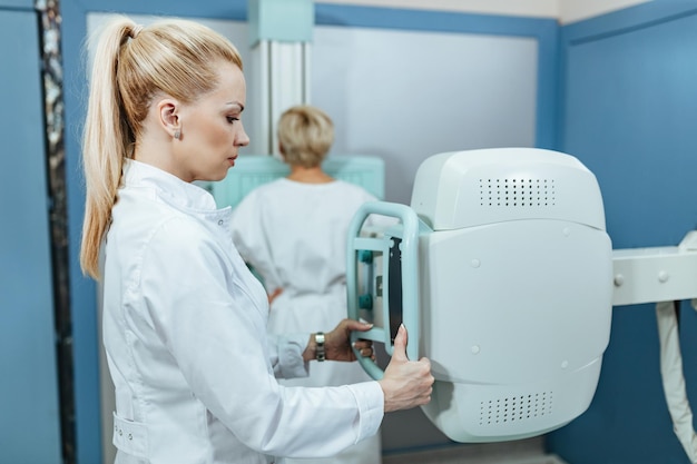 Ärztin beim Röntgen eines Patienten im Untersuchungsraum des Krankenhauses