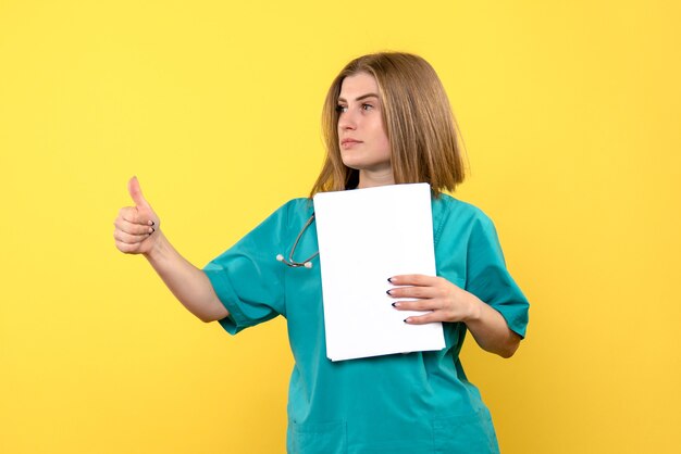 Ärztin der Vorderansicht, die Dateien auf medizinischem Krankenhaus der gelben Bodenkrankheit hält