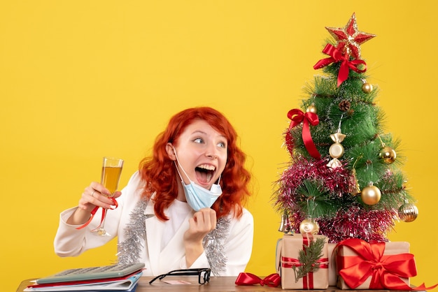 Ärztin der Vorderansicht, die Weihnachten mit Glas Champagner feiert