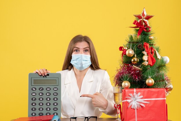 Ärztin der Vorderansicht im Taschenrechner der sterilen Maske