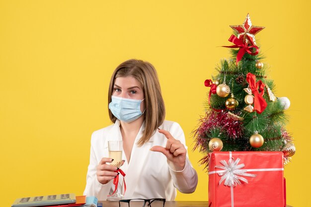 Ärztin der Vorderansicht in der sterilen Maske, die Weihnachten feiert