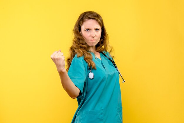 Ärztin der Vorderansicht wütend auf gelben Raum