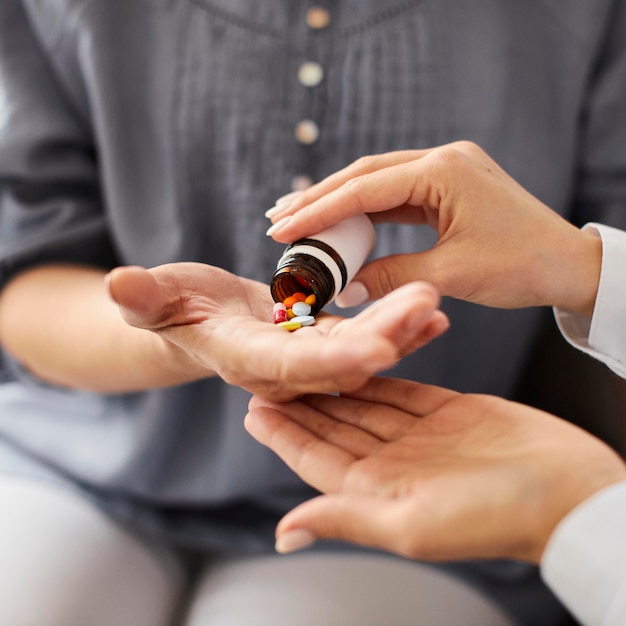 Ärztin des Covid Recovery Center, die älteren Patienten Tabletten in der Hand gibt