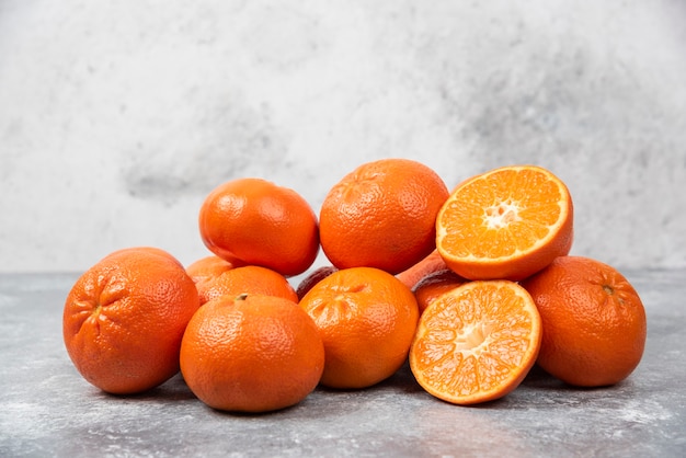 Saftige Orangenfrüchte mit Scheiben auf Steintisch.
