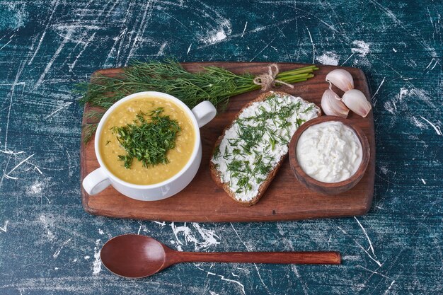 Sahnesuppe mit Kräutern, Sauerrahm und dunklem Brot.