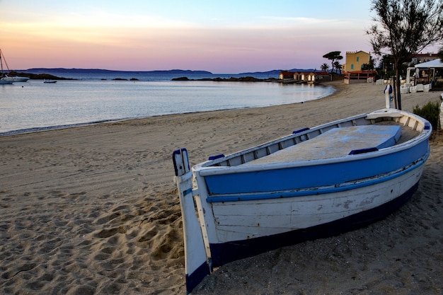 Saint Clair Strand mit einem Boot und Gebäuden darauf, umgeben vom Meer und den Hügeln in Frankreich