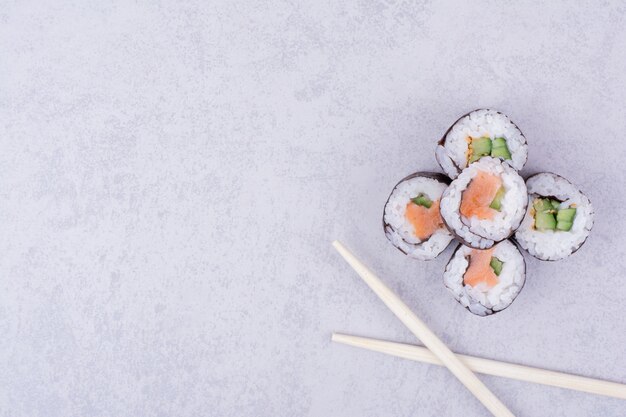 Sake Maki Brötchen mit Lachs und Avocado auf grau.