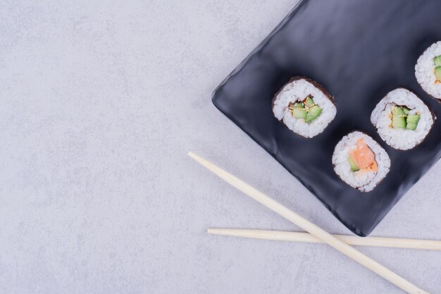 Sake Maki Rolls mit Lachs und Avocado in einer schwarzen Keramikplatte