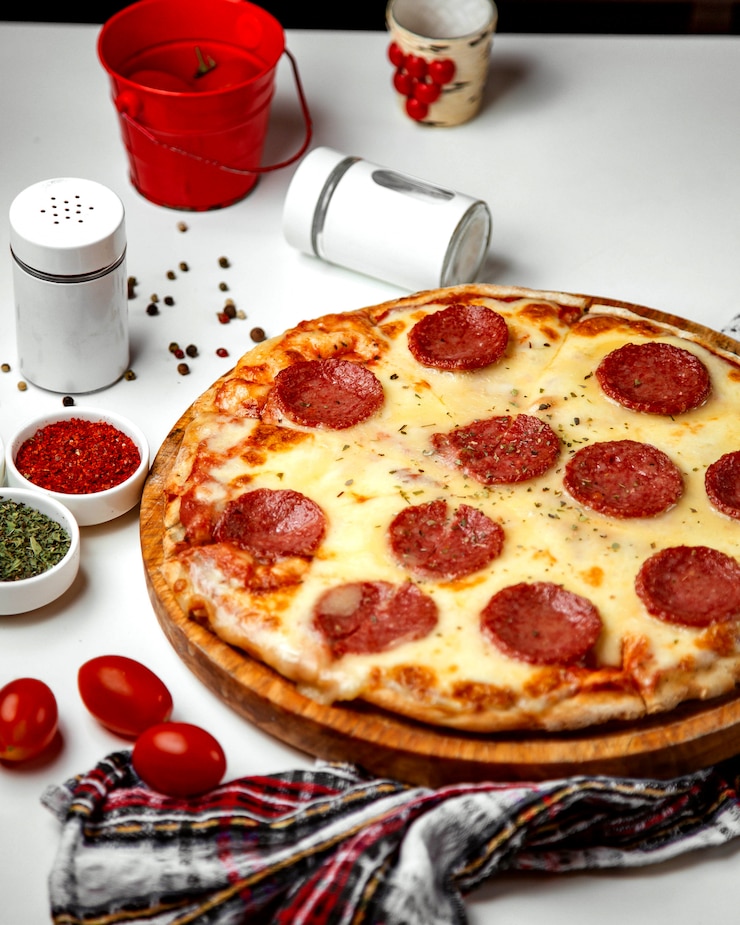 Kostenlose Foto salamipizza überstiegen mit getrockneten kräutern