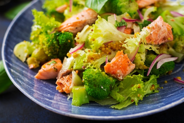 Salat aus gedünstetem Fischlachs, Brokkoli, Salat und Dressing. Fischmenü. Diätmenü. Meeresfrüchte - Lachs.