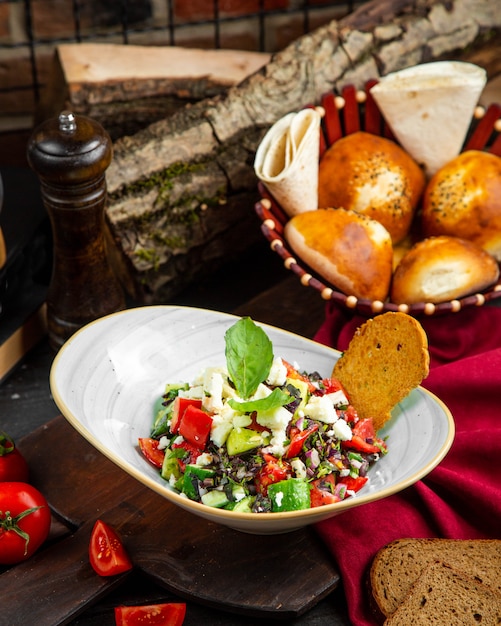 Kostenloses Foto salat aus gurken und tomaten mit käse und gemüse mischen