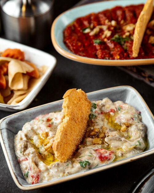 Salat in Sauerrahm mit Öl und Cracker gekrönt