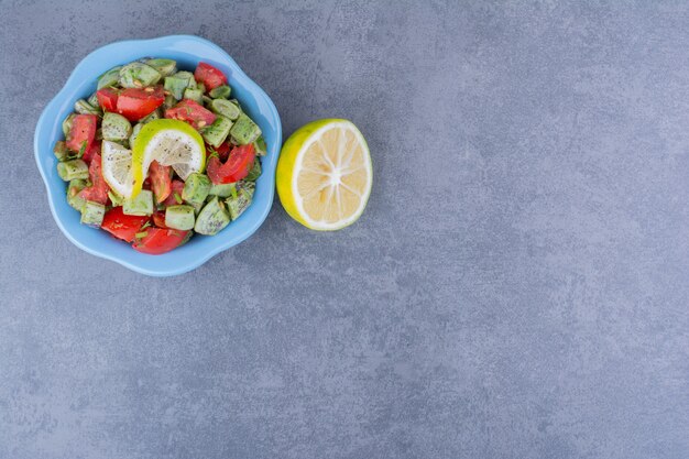 Salat mit gehackten Tomaten und grünen Bohnen, serviert mit Zitrone