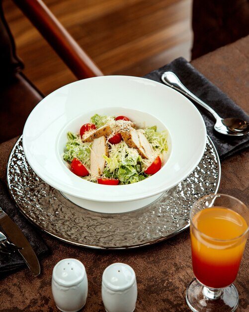 Salat mit Hühnchen und einem Glas Saft