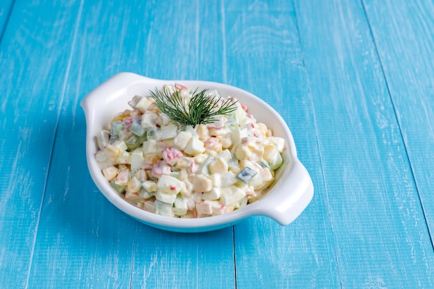 Salat mit Krabbenstangen, Eiern, Mais und Gurke.