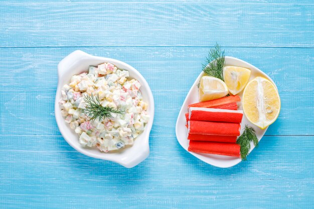 Salat mit Krabbenstangen, Eiern, Mais und Gurke.