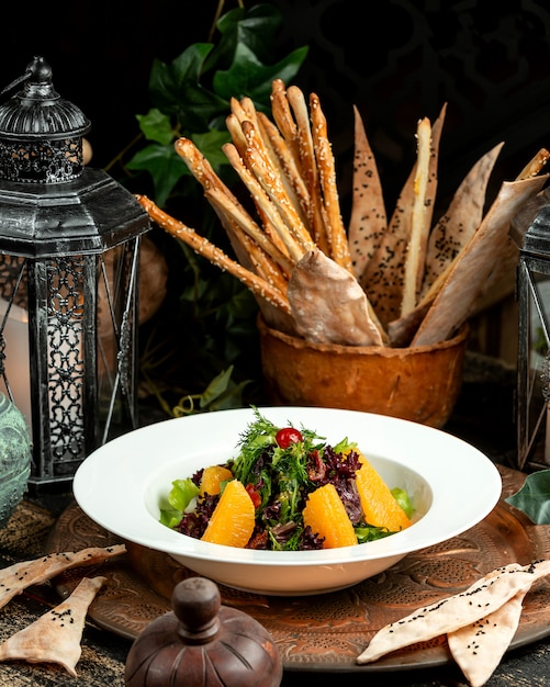 Salat mit Rucola-Grün-Orange und Tomate mit Brotgebäck