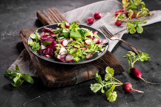 Salat mit verschiedenen Zutaten auf dunklem Teller