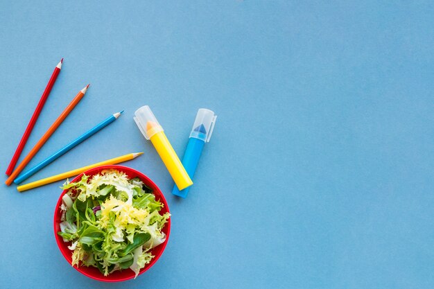 Salat nahe Bleistiften und Markierungen