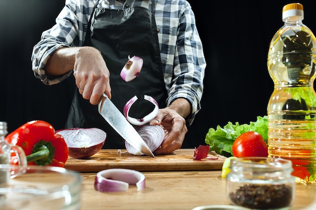 Salat zubereiten. Köchin, die frisches Gemüse schneidet. Kochvorgang. Selektiver Fokus