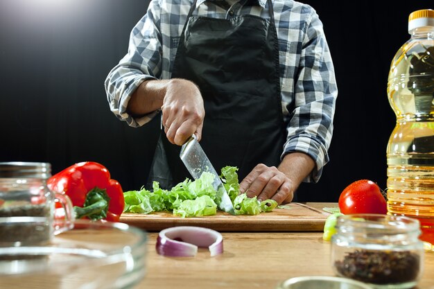 Salat zubereiten. Köchin, die frisches Gemüse schneidet.