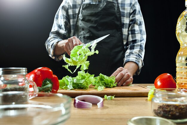 Salat zubereiten. Köchin, die frisches Gemüse schneidet.