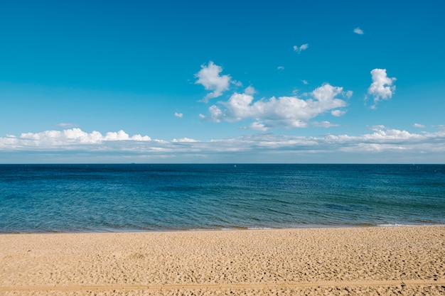 Sand und Meer und Hintergrund des blauen Himmels