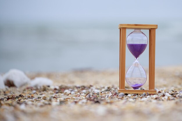 Sanduhr am Strand auf dem Boden Hochwertiges Foto