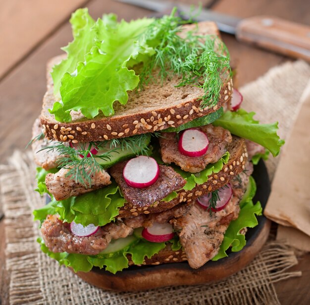 Sandwich mit Fleisch, Gemüse und Scheiben Roggenbrot