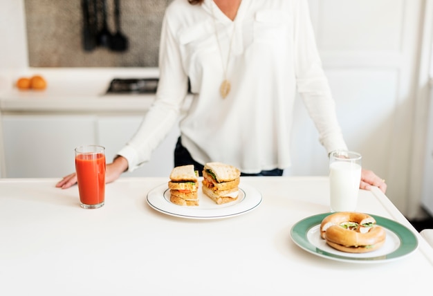 Sandwiche mit Saft und Milch auf weißer Tabelle in der Küche