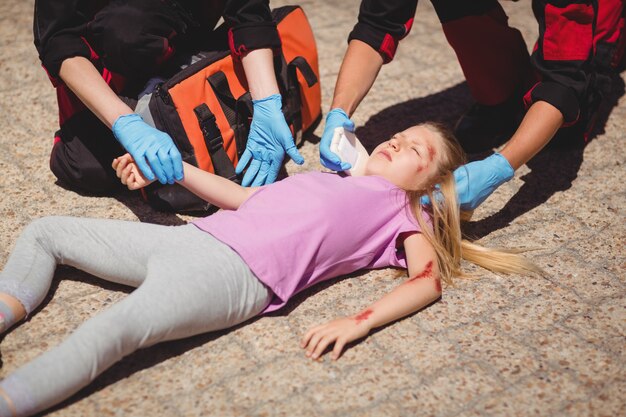 Sanitäter untersuchen verletztes Mädchen