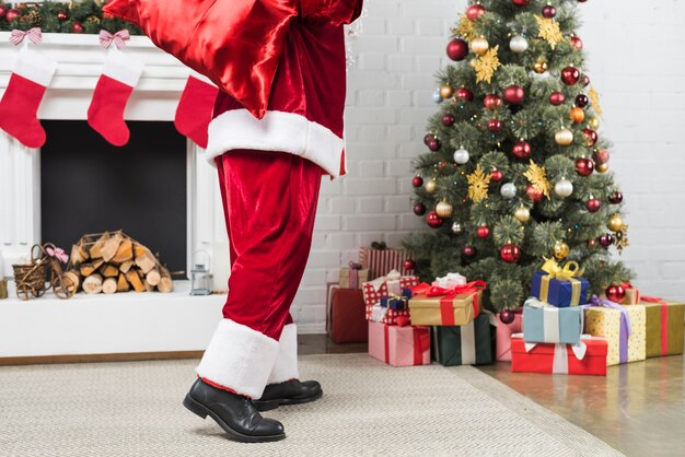 Sankt mit Sack Geschenken hinten gehen zum Weihnachtsbaum