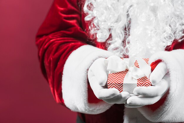 Santa Claus, die Geschenkbox mit Band in den Händen hält