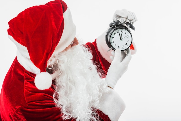 Kostenloses Foto santa claus, die uhr in den händen betrachtet