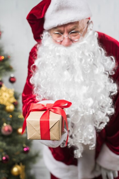 Kostenloses Foto santa claus im hut mit geschenkbox in der hand