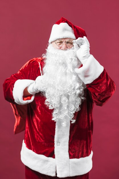 Santa Claus in den Gläsern mit großem Sack hinten zurück