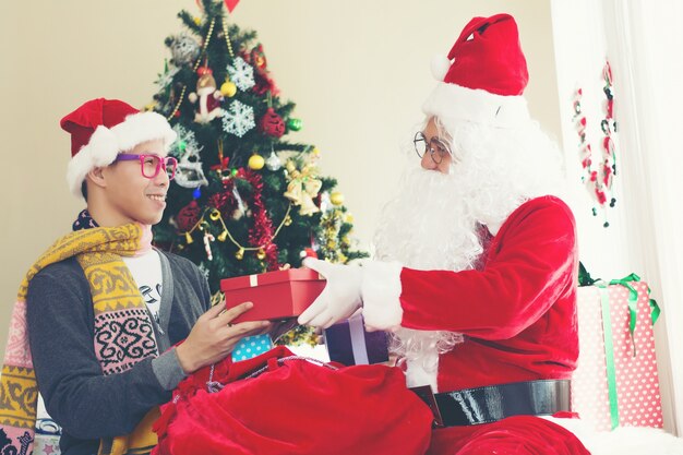 Santa Claus und der junge Junge mit Geschenkboxen