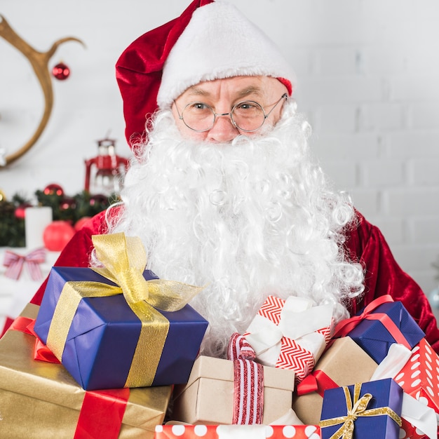 Kostenloses Foto santa mit geschenkboxen in händen