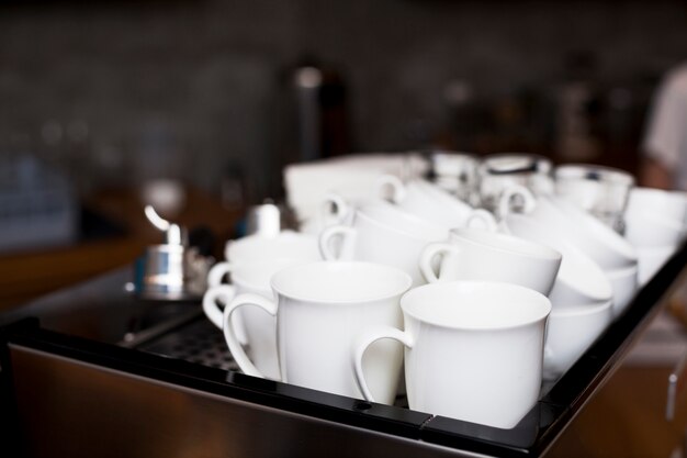 Satz der weißen Kaffeetasse auf Behälter in der Cafeteria